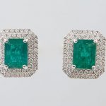 Pair of Platinum Earrings, with a central 1.98 ct. emerald atop a double concentric graduated border of round diamonds, with a screw post, total emerald