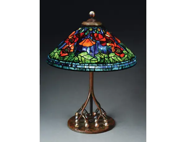 Tiffany Studios table lamp with 20in conical leaded-glass shade in ‘Poppy’ motif exhibiting the very highest standards of Tiffany artistry. Astounding colorway and complex composition. Exceptionally rare base with 16 iridescent Favrile-glass balls as supports for the telescoping stem. Tiffany stamps to both shade and base. Estimate $350,000-$450,000