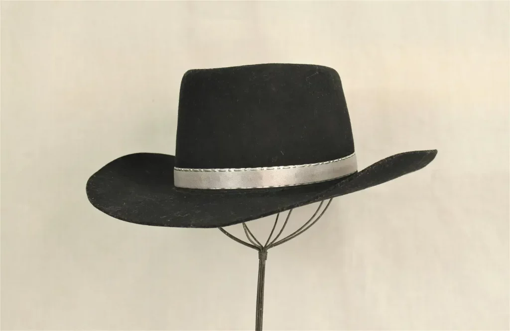 Silver-banded black hat worn by John Wayne in the film ‘Red River,’ as seen in movie studio publicity hand-out photo. Described by ‘Entertainment Magazine’ as one of the most iconic hats in film history. Extensive documentation includes Boyd Magers LOA, and signed affidavit. $10,000-$30,000