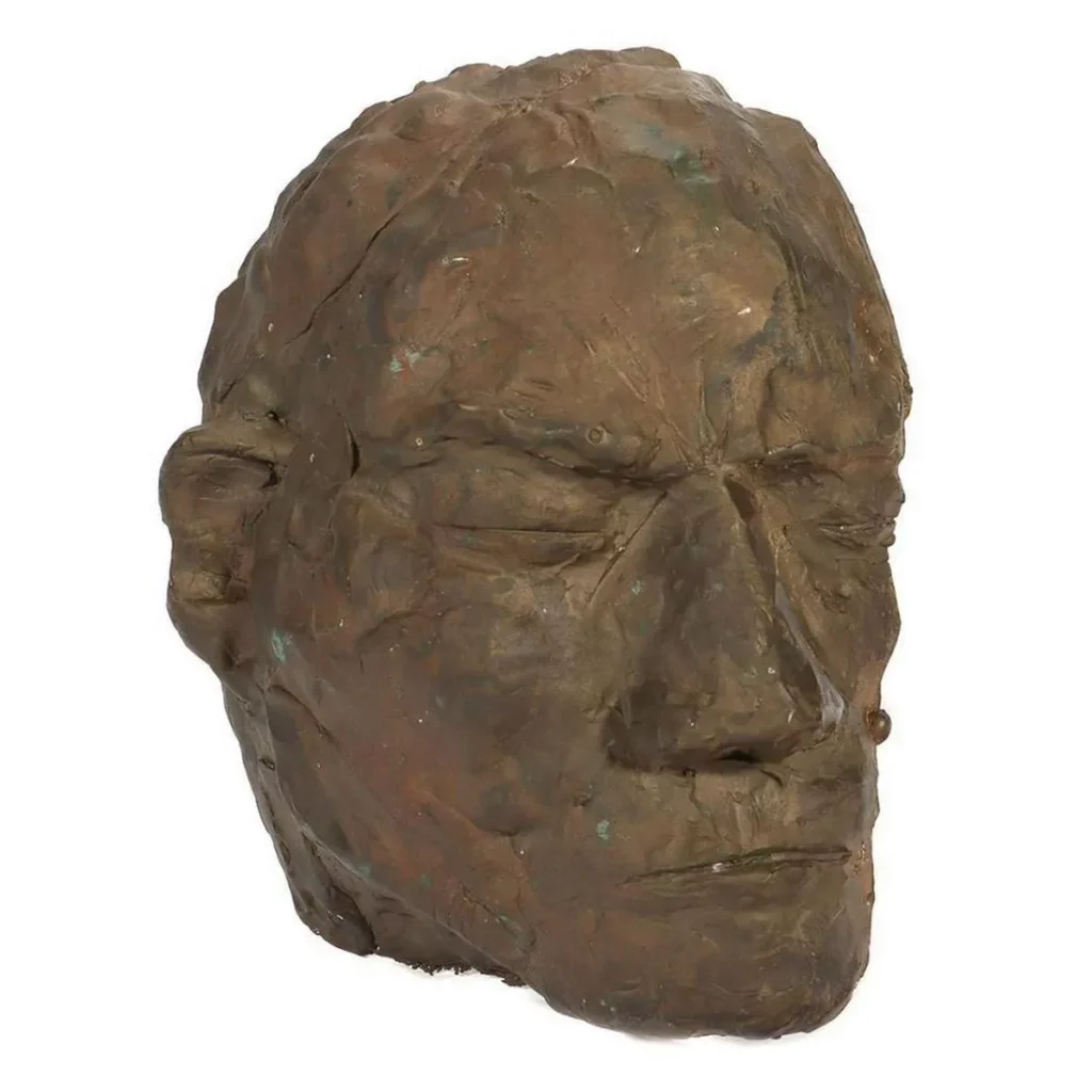 Lot 41:  Artist: Eleen Auvil (1927 - 2022). Title/Subject: Profile mask. Size: 9in. x 7 1/2in. Year Created: Undated. Signature: Unsigned. Medium/Ground: Cast bronze. Condition good, patina. Estimate $200-$400.