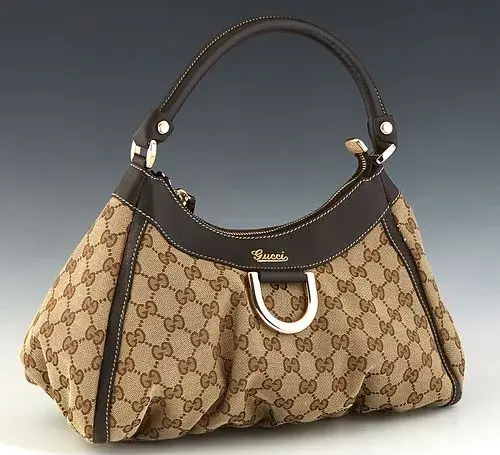 Gucci D-Ring Hobo, in beige and brown monogrammed canvas with brown leather accents and gold hardware, opening to a brown canvas lined interior with zip pocket, H.- 8 in., W.- 12 1/2 in., D.- 6 in., Strap L.- 6 1/2 in.