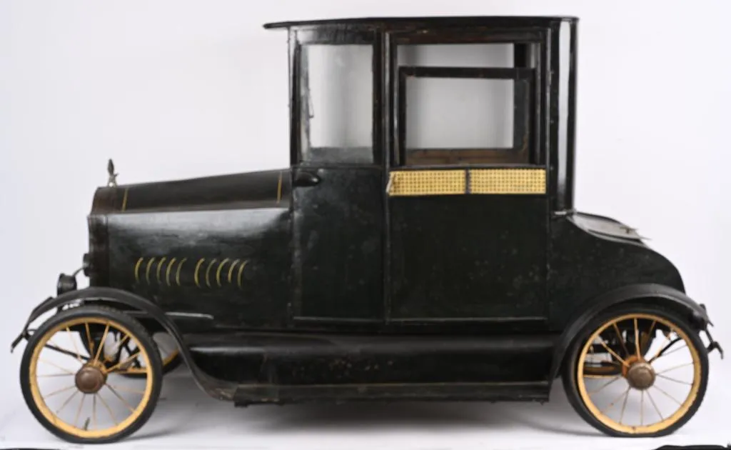 American National Deluxe Coupe pedal car, luxury version with opening doors, sliding windows, interior upholstery and curtains. Length: 68 inches. Sold for $66,000 against an estimate of $20,000-$40,000