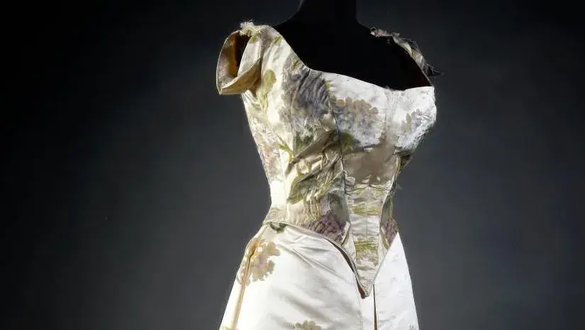 Worth ballgown, c. 1900, velours au sabre with cream satin background decorated with sinuous hydrangea plants in bloom, boned pointed bodice, fastened and laced at the back, with short sleeves and neckline originally edged with ruffled tulle, apron with open front panels over a cream satin skirt with long train (some minor damage; skirt dismantled).
Estimate: €2,000/3,000