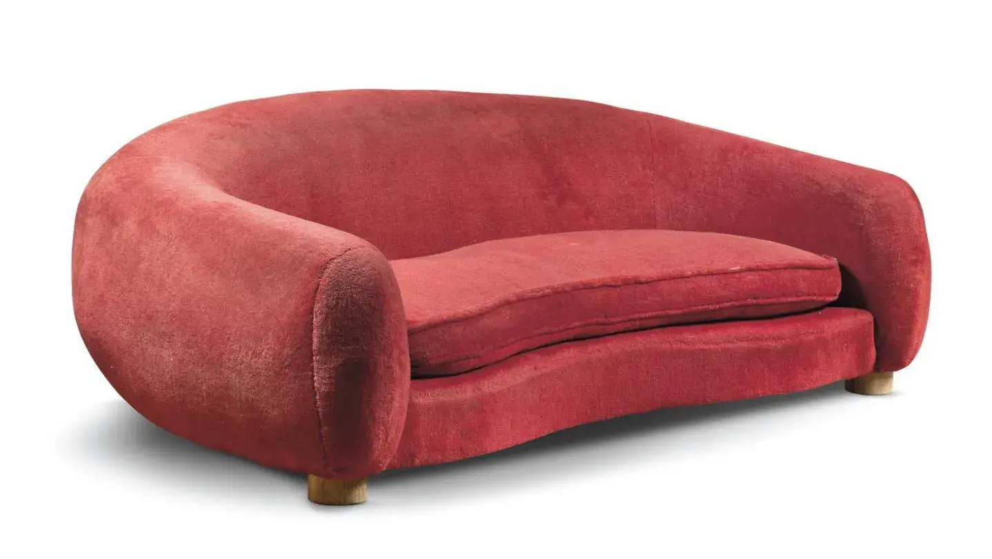 Jean Royère (1902-1981), “Polar Bear” Boule sofa, c. 1952, beechwood frame, banana backrest and seat cushion, entirely upholstered in the original red mohair velvet, five cylindrical oak legs, 78 x 230 x 130 cm/ 30.70 x 90.55 x 51.18 cm. Result: €1,012,500