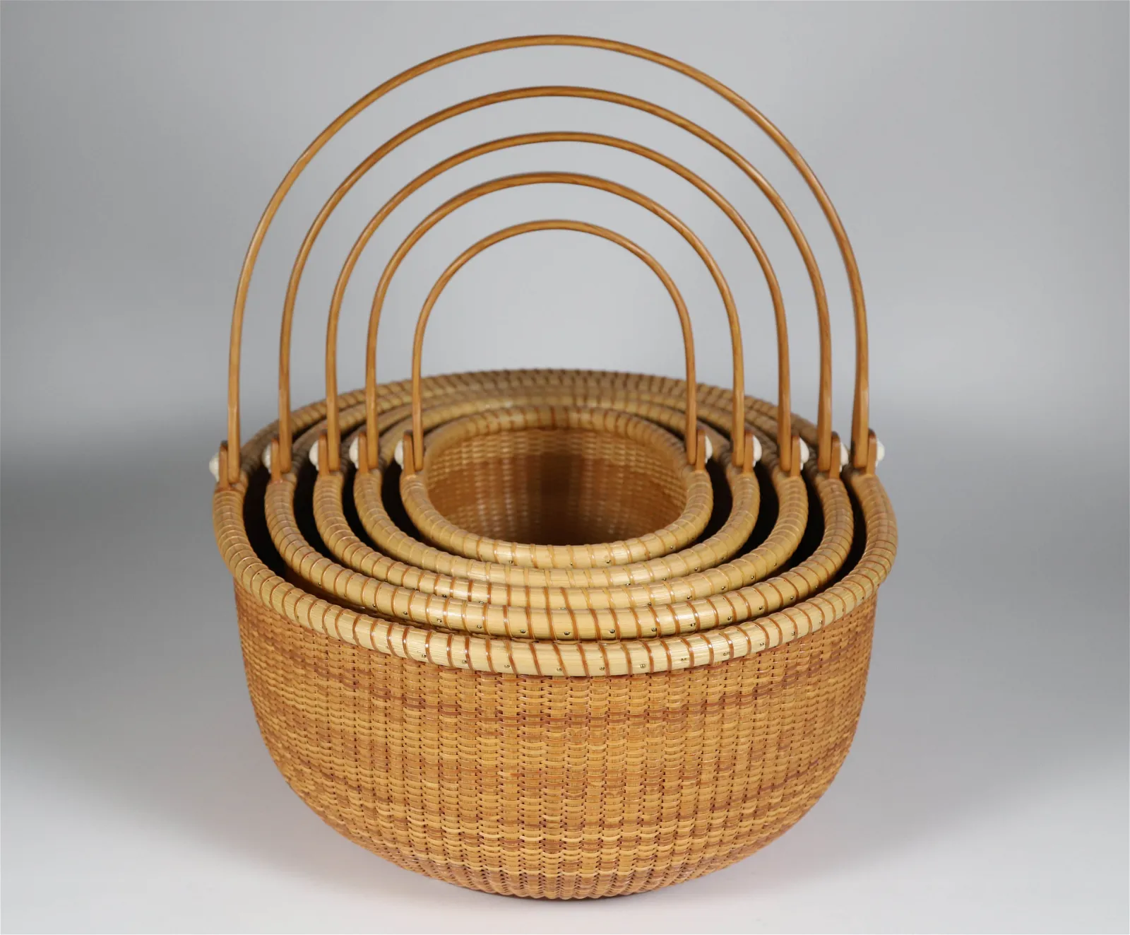 Nest of five vintage Bill and Judy Sayle oval Nantucket baskets, circa 2000. Image courtesy of Rafael Osona Auctions. 
