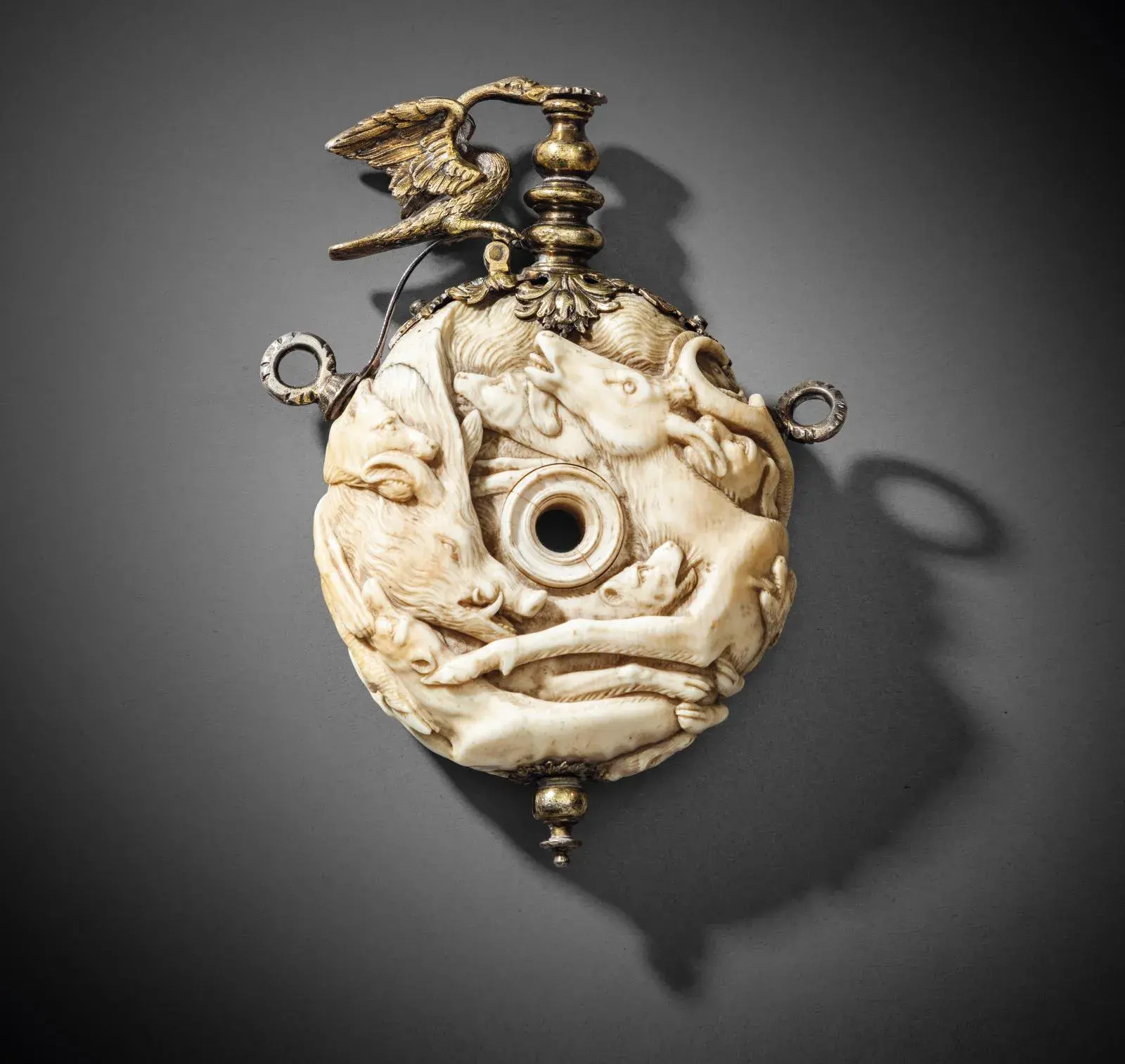 Germany, 17th century, in the manner of Johann Michael Maucher of Schwäbish-Gmünd (1645-1701). Round powder flask in ivory carved in high relief with intertwined animals, gilded silver mount with pouring spout and spring-loaded swan flap, h. 17 cm/6.69 in.
Estimate: €10,000/12,000